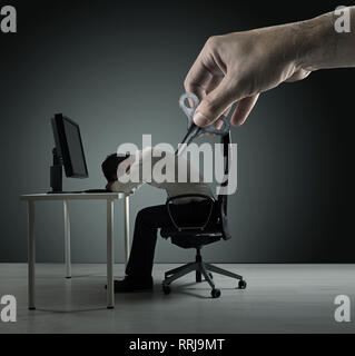Conceptual picture of an exhausred office worker being winded up Stock Photo