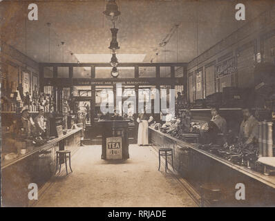 Vintage Photographic Postcard Showing The Interior of Sainsbury's Chief Office and Stores at Blackfriars in London, England. Staff Waiting Behind Their Serving Counters. Stock Photo