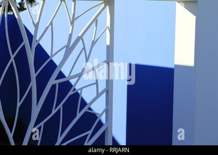 White architecturally designed security door with blue background in Vale da Telha, Arrifana, Aljezur, Algarve, Portugal Stock Photo