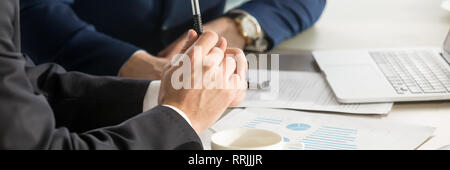 Horizontal cropped image businessmen brainstorming using charts shown at papers Stock Photo