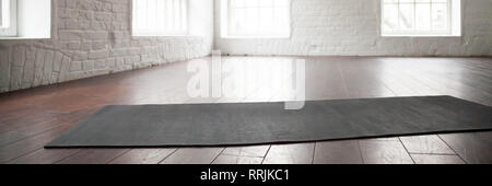 Horizontal photo yoga mat on wooden floor at sport club Stock Photo