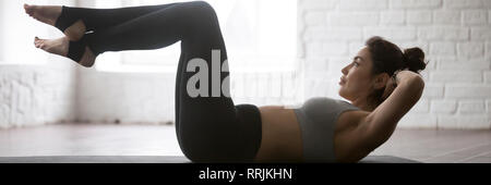 Horizontal photo beautiful sportive woman doing upper lower abdominal crunches Stock Photo