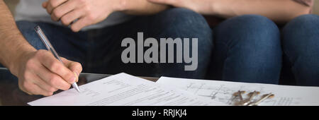 Close up male holds pen putting signature on rental agreement Stock Photo