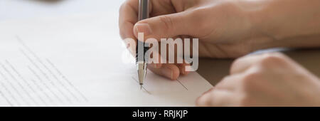 Closeup male hand holding pen put signature on official document Stock Photo