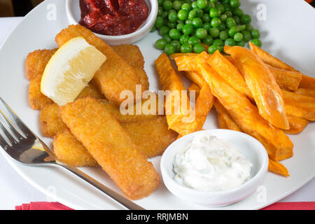 Classic English pub lunch of Fish fingers, chips and garden peas served with homemade Tomato ketchup, Tartar sauce and fresh Lemon wedge. Stock Photo