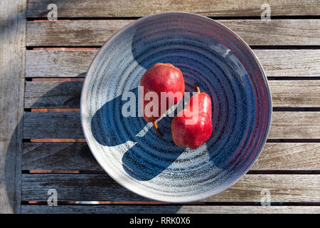 Yin and Yang formed by red pears on ceramic plate. Stock Photo
