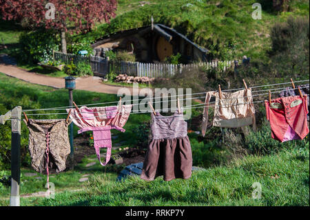 Hobbiton movie set created to film Lord of the Rings and The Hobbit. Washing hanging in the sun on a wooden clothes line in lush green grass Stock Photo