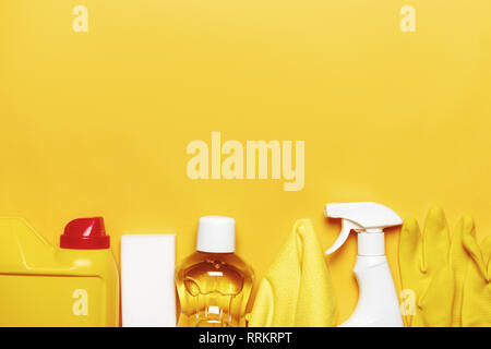 Set for cleaning various surfaces in the kitchen, bathroom and other areas. Empty place for text on yellow background. Cleaning concept. Top view Stock Photo