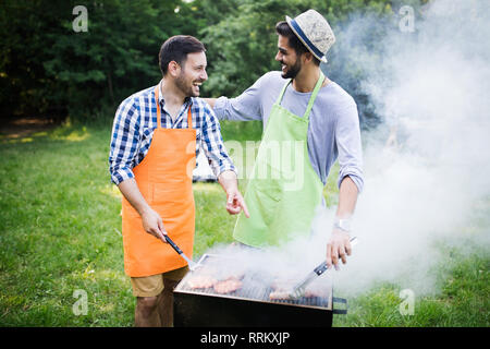 Group of friends making barbecue in the nature Stock Photo