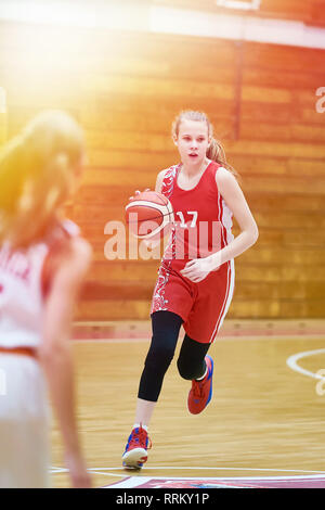 Girl basketball player with a ball in the game Stock Photo