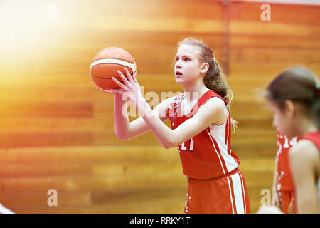 Girl basketball player throws the ball in the game Stock Photo