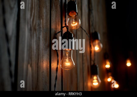 Edison light bulb hanging on a long wire. Cozy warm yellow light.Retro Stock Photo