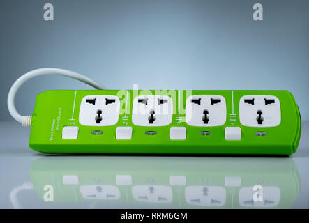 High quality and safety power strip with four electrical standard socket. Green universal plug with overload protection. Fire resistant material for Stock Photo