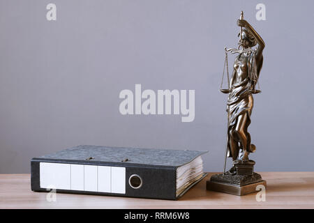 lady justice or justitia statue and file folder on desk Stock Photo