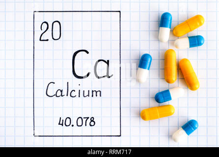 Handwriting chemical element Calcium Ca with pills. Close-up. Stock Photo