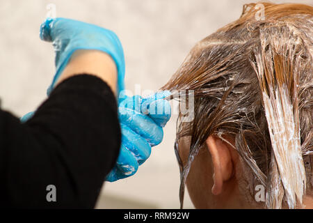 Hairdresser dying a woman's hair Stock Photo