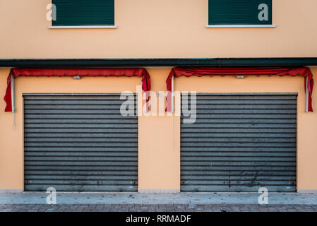Two closed shutters with red curtains Stock Photo