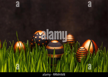Easter background. Easter eggs in various golden designs hiding in green grass Stock Photo