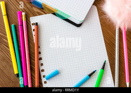 Empty squared page with open felt tip pens on wooden desk. Stock Photo