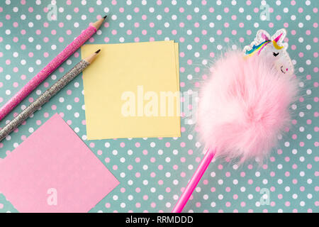 Colorful funny pencils with memo notes on dotted green background. Stock Photo