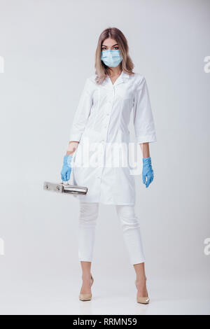 woman doctor with face mask and medical gloves holds a metal bag with medical instruments Stock Photo