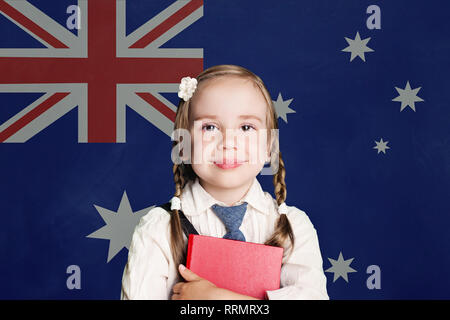 Australia concept with little girl student with book on the Australian flag background Stock Photo