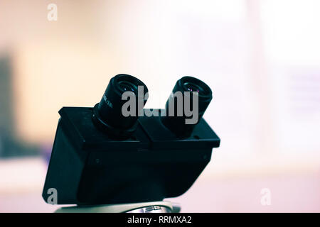 eye piece of a binocular light microscope black in colour in white background Stock Photo