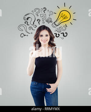 Happy woman with yellow lightbulb showing thumb up. Brainstorm, ideas, problem and solution concept Stock Photo