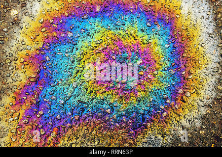 Colorful oil stain on asphalt driveway, top view as abstract background Stock Photo