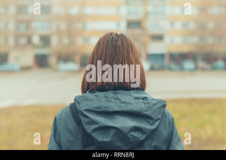 Rear view of woman on city street in cold winter afternoon Stock Photo