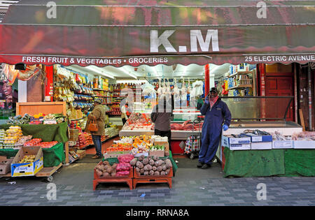 K.M Brixton street market selling fruit and veg vegetables on Electric Avenue in Brixton South London SW9 England UK  KATHY DEWITT Stock Photo
