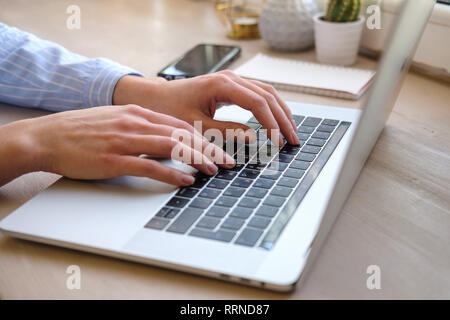 Working at home with laptop woman writing a blog. Female hands on the keyboard. Close up Stock Photo