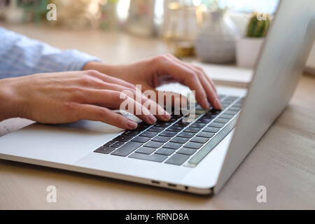 Working at home with laptop woman writing a blog. Female hands on the keyboard. Close up Stock Photo