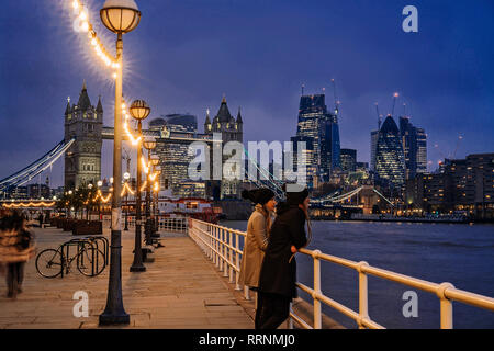 Couple standing along Thames River, London, UK Stock Photo
