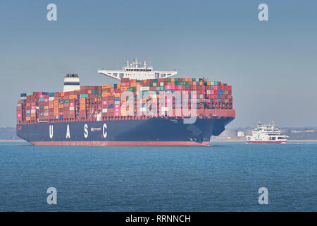 The 400 metre, Ultra-Large, Container Ship, TIHAMA, Passing A Red Funnel Car Ferry In The Southampton Harbour Deep Water Channel, Hampshire, UK. Stock Photo