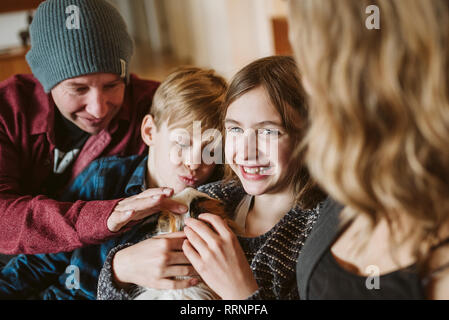 Portrait happy family petting guinea pig Stock Photo