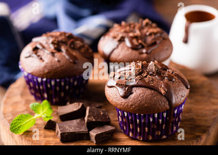 Chocolate muffins or cupcakes decorated with chocolate ganache. Closeup view Stock Photo