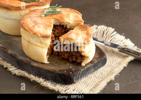 Australian meat pie on wooden table close-up with copy space, rustic style Stock Photo