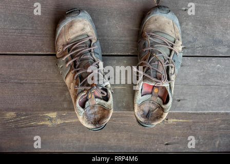 Top view on an old worn boots standing on a wooden floor Stock Photo
