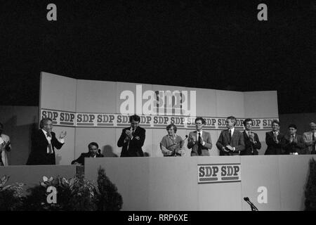 Dr David Owen (seated), former leader of the Social Democratic Party, receives a standing ovation from national committee members on the platform after his speech at the party's conference in Portsmouth. (L-R) Dr Owen, former MP Ian Wrigglesworth, party president Shirley Williams, unidentified, new party leader Robert Maclennan and vice-president Bill Rodgers. Stock Photo