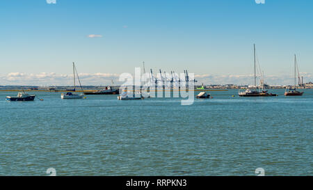 Queenborough, Kent, England, UK - September 22, 2017: Boats on the River Medway with harbour cranes in the background Stock Photo