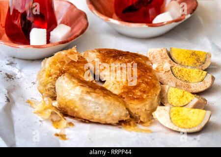 Boyoz (a Turkish pastry associated with İzmir) with the traditional accompaniments of tea and hard-boiled eggs with black pepper Stock Photo