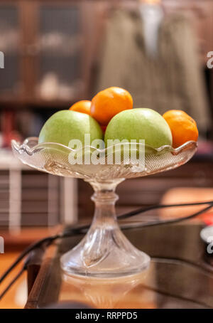 Apples and tangerine on table arranged in glass tray or bowl Stock Photo