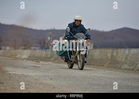 (190226) -- CHANGCHUN, Feb. 26, 2019 (Xinhua) -- Postman Jin Renzhe is on the way to deliver postal packages in Chunhua Township of Huichun City, northeast China's Jilin Province, Feb. 19, 2019. Jin Renzhe has been working as a postman for 30 years in Chunhua Township, where postal service is inadequate because of steep mountain paths and loosely-scattered villages. Despite that, Jin manages to deliver mails to villagers the same day mails arrive in the town. As many young people work outside the town, Jin bridges them and their parents through delivering packages. Living with eye disease and  Stock Photo