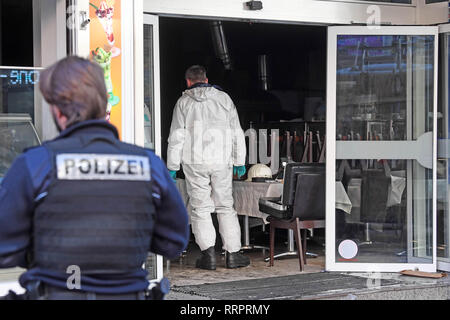 26 February 2019, Baden-Wuerttemberg, Karlsruhe: A police officer is standing in front of a burnt-out doner kebab bite in downtown Karlsruhe. In the background you can see a forensic expert. The fire in the early morning burnt out the snack bar and caused six-figure damage. The police are assuming arson. Already in the middle of December last year, petrol had been spilled in the building by unknown perpetrators. The attempt to light the place on fire was unsuccessful at the time, it was said. Whether there was a connection between the two incidents must now be determined. Photo: Uli Deck/dpa Stock Photo