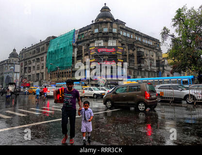 Kolkata, WEST BENGAL, India. 26th Feb, 2019. A man seen with a kid walking with on the busy street of kolkata during Rain.Due to a depression and Western Disturbance kolkata and other parts of Bengal faced light to Moderate Rain with Thunderstorm which is affecting daily life. Credit: Avishek Das/SOPA Images/ZUMA Wire/Alamy Live News Stock Photo