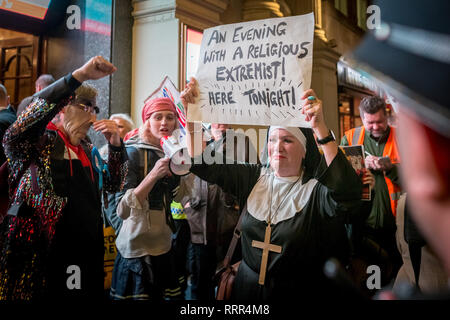 Transgender activist, Tara Wolf(pictured with megaphone), joins the Class War protest. Protesters from Class War anarchist group hold a lively demonstration outside the London Palladium theatre against the evening talk featuring Jacob Rees-Mogg, Conservative MP and prominent Brexit supporter. Class War members, including long-time anarchist, Ian Bone, Jane Nicholl (pictured dressed as a nun) and Adam Clifford (left, as Rees-Mogg parody) claim Mr Rees-Mogg, a Catholic, is a religious extremist because of his outspoken views on abortion. London, UK. Stock Photo