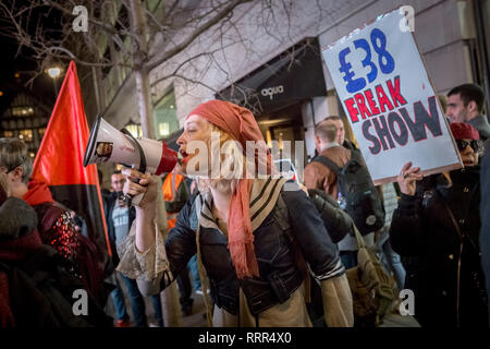 Transgender activist, Tara Wolf(pictured), joins the Class War protest with loud hailer. Protesters from Class War anarchist group hold a lively demonstration outside the London Palladium theatre against the evening talk featuring Jacob Rees-Mogg, Conservative MP and prominent Brexit supporter. Class War members, including long-time anarchist, Ian Bone, Jane Nicholl (dressed as a nun) and Adam Clifford (as Rees-Mogg parody) claim Mr Rees-Mogg, a Catholic, is a religious extremist because of his outspoken views on abortion. Stock Photo