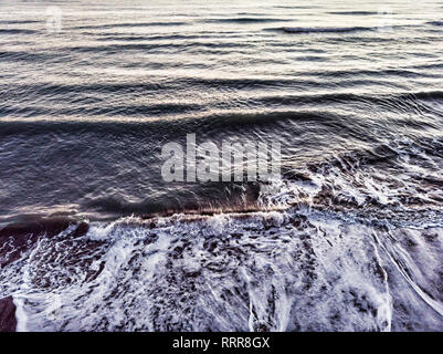 Ocean wave breaks into the coast with backwash Stock Photo