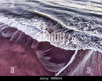 Ocean wave breaks into the coast with backwash Stock Photo